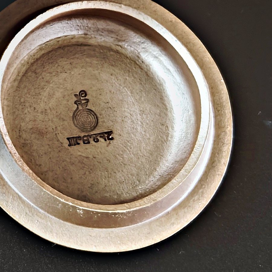 The Parables maker's mark pressed into the clay