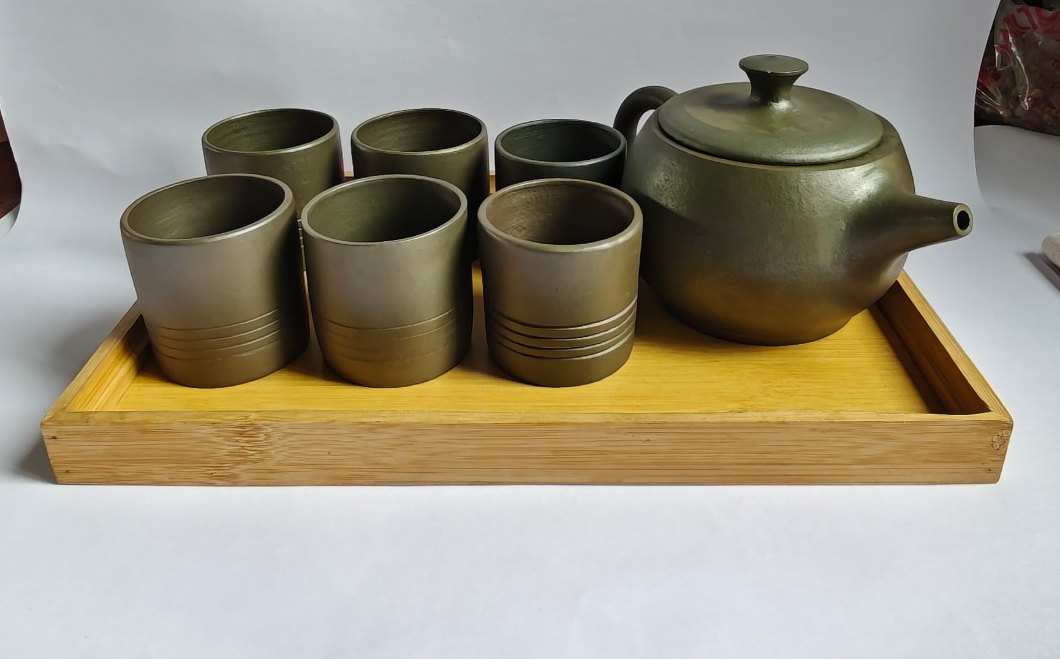 A Parables round teapot and tasting cups on a bamboo tray